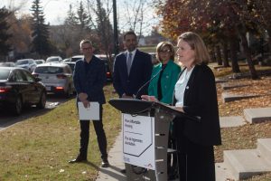 Sarah Woodgate, President and CEO of Calgary Housing, delivers remarks at the joint funding announcement Oct. 16, 2024 in Calgary. Calgary Mayor Jyoti Gondek, Skyview MP George Chahal (Centre), and Jeff Chase, City of Calgary’s Chief Housing Officer, look on.