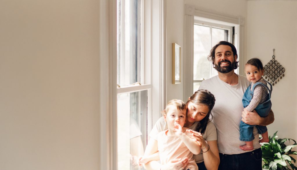 A family of a man, a woman and two children are pictured inside a home.